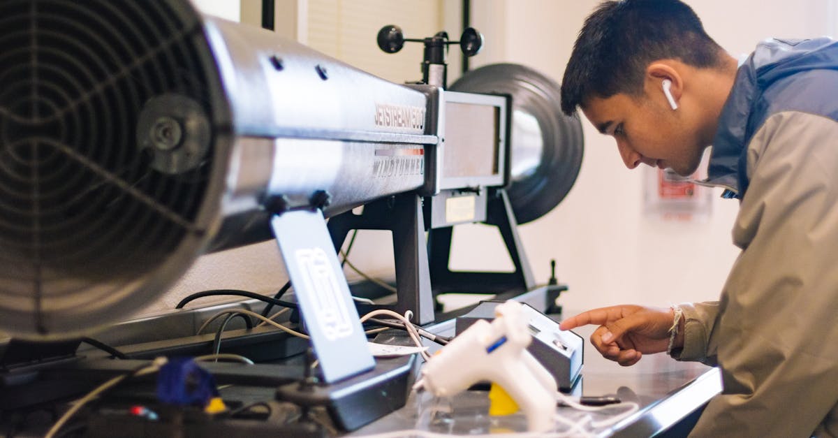 Young student interacts with jetstream apparatus in an engineering lab.