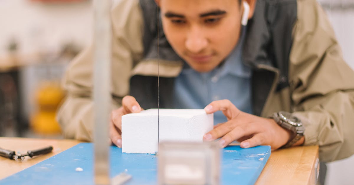 Student intensely concentrating on a workshop project with precision tools.